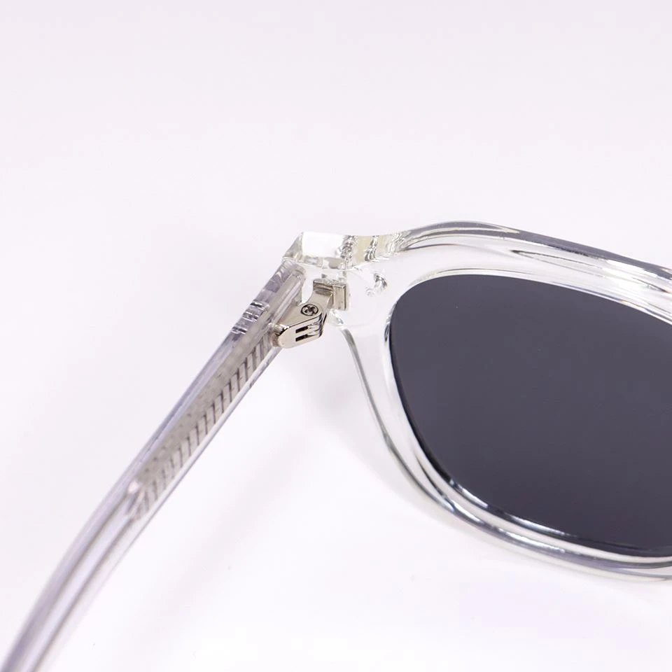 Close-up of clear acetate frame edge and polarized lens fit on custom eyewear front Close-up of clear acetate frame edge and polarized lens fit on custom eyewear front