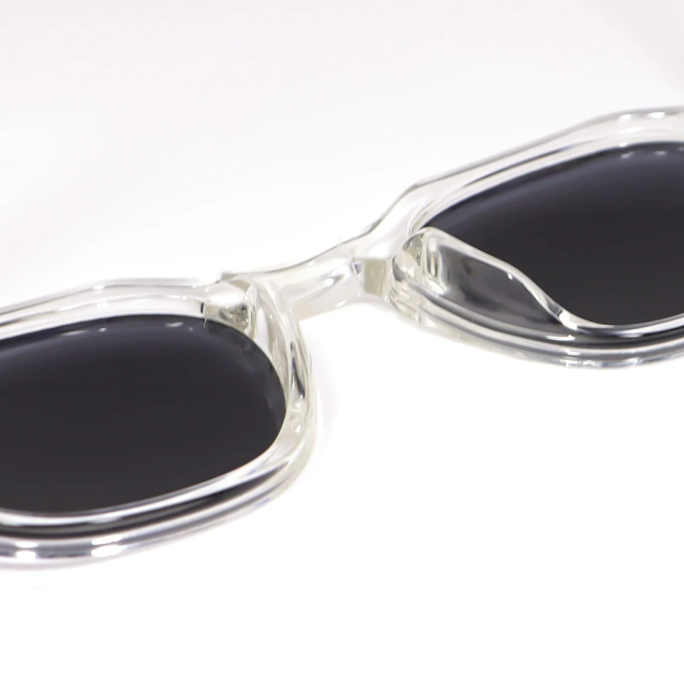 Detail shot of dark polarized lenses on transparent acetate sunglasses frame Detail shot of dark polarized lenses on transparent acetate sunglasses frame